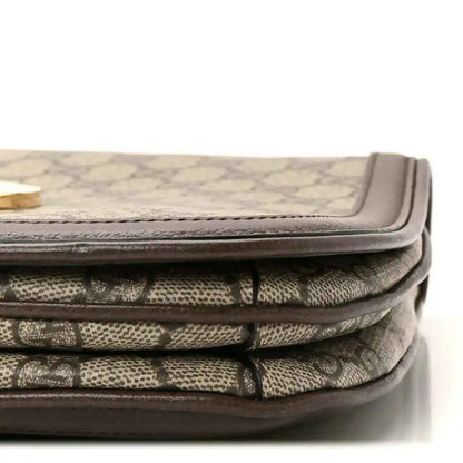 Bag corner showing beige GG monogram canvas folds with brown leather binding