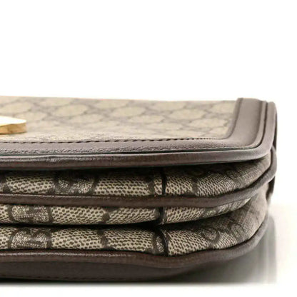 Bag corner showing beige GG monogram canvas folds with brown leather binding