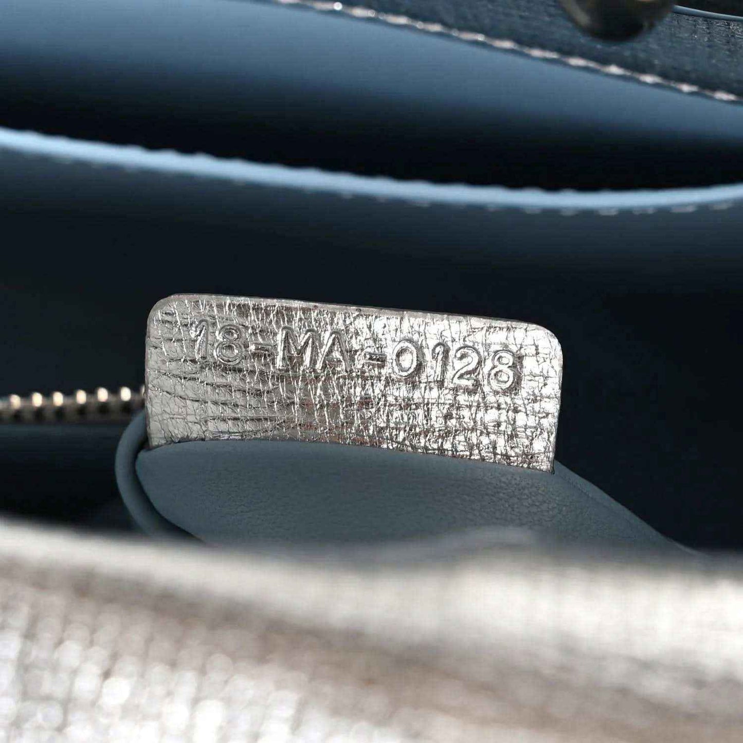 Blue leather bag lining with embossed code tag and zipper edge