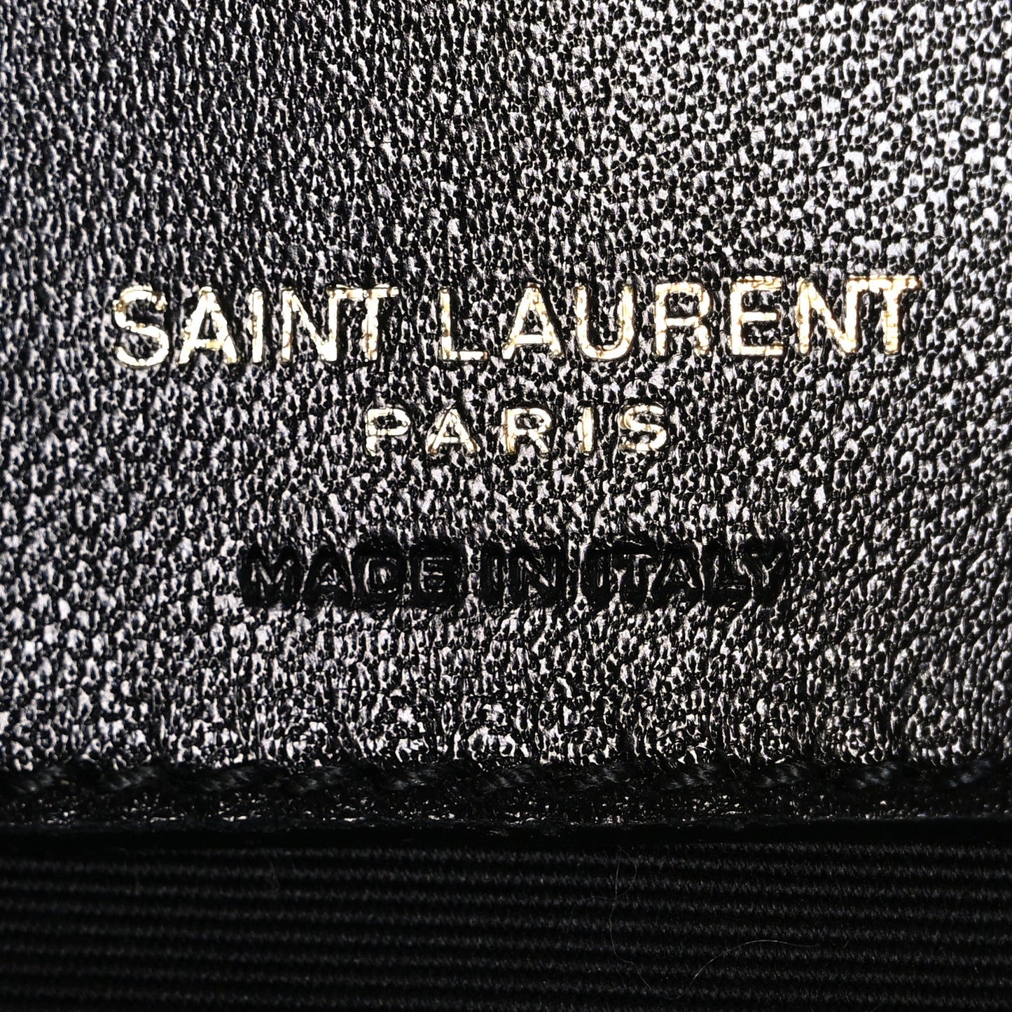 Black textured leather interior label with "SAINT LAURENT PARIS" embossing