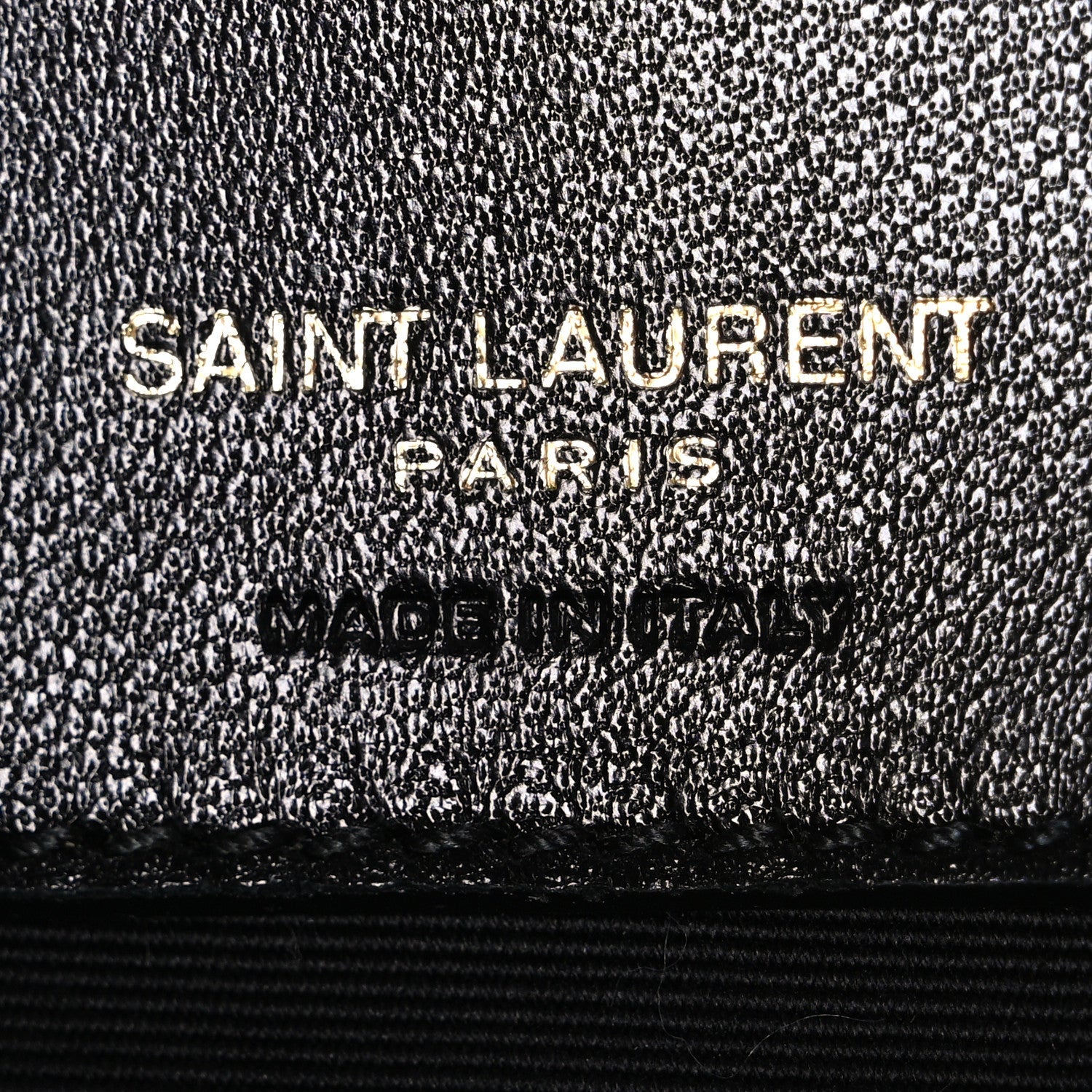 Black textured leather interior label with "SAINT LAURENT PARIS" embossing