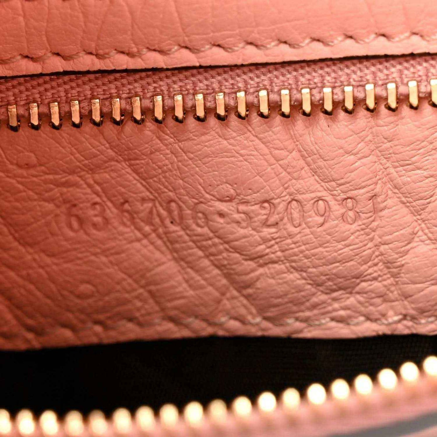 Gucci small hobo bag zipper close-up on pale pink grained leather