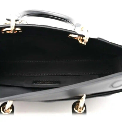 Black leather interior of quilted handbag with zipper hardware and stitched trim