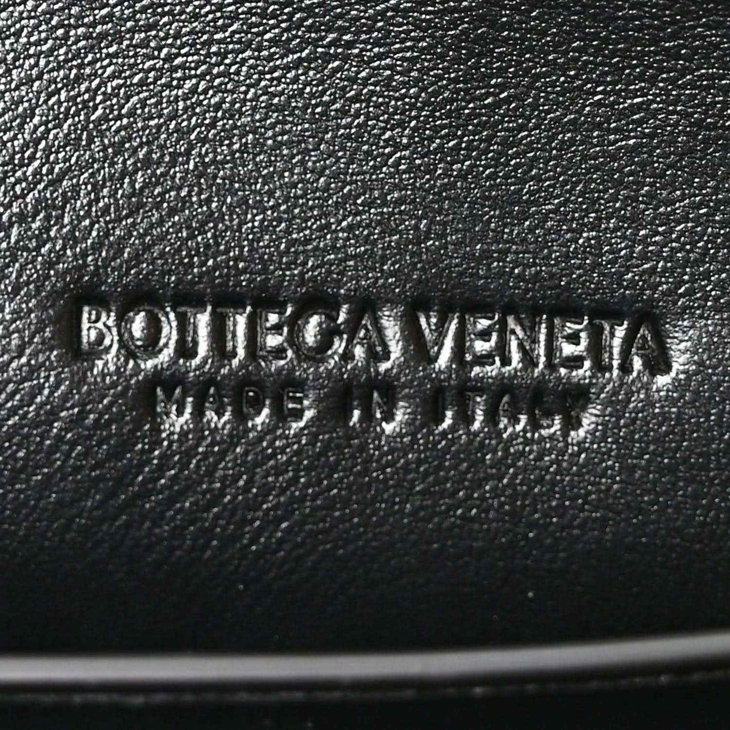 Bottega Veneta logo stamp on black leather clutch