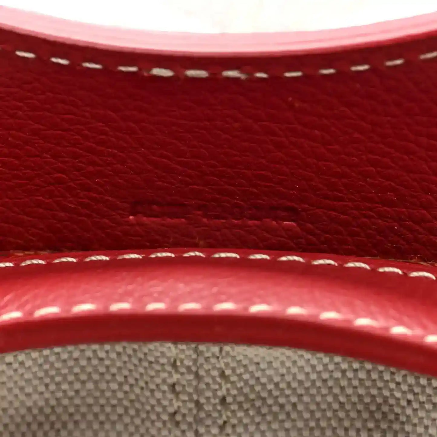 Red leather trim with white stitching detail on mini handbag edge