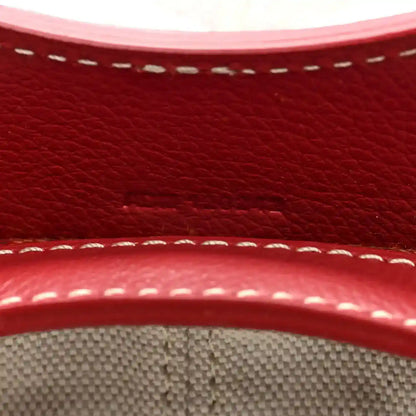Red leather trim with white stitching detail on mini handbag edge