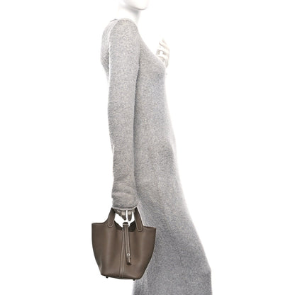 Taupe leather tote bag, side profile with top handles and lock closure