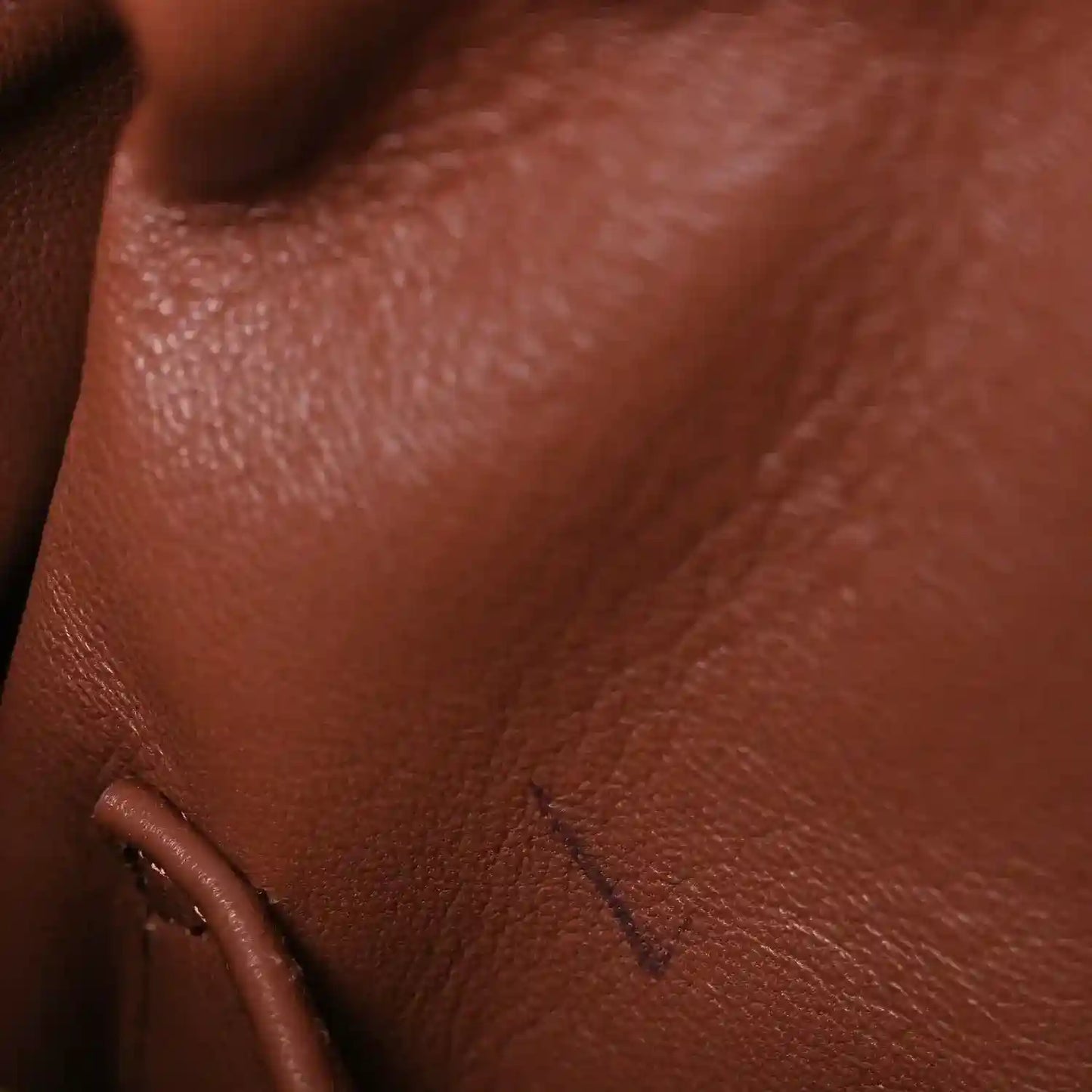 Pecan brown leather close-up with embossed stitch detail and smooth grain texture