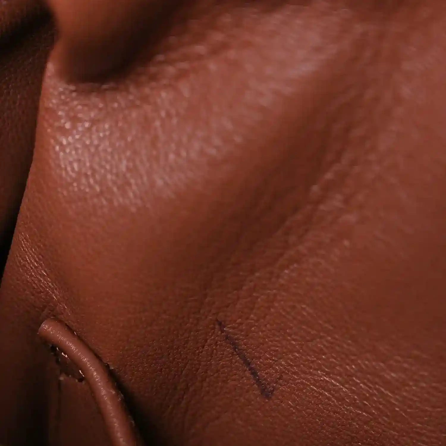Pecan brown leather close-up with embossed stitch detail and smooth grain texture