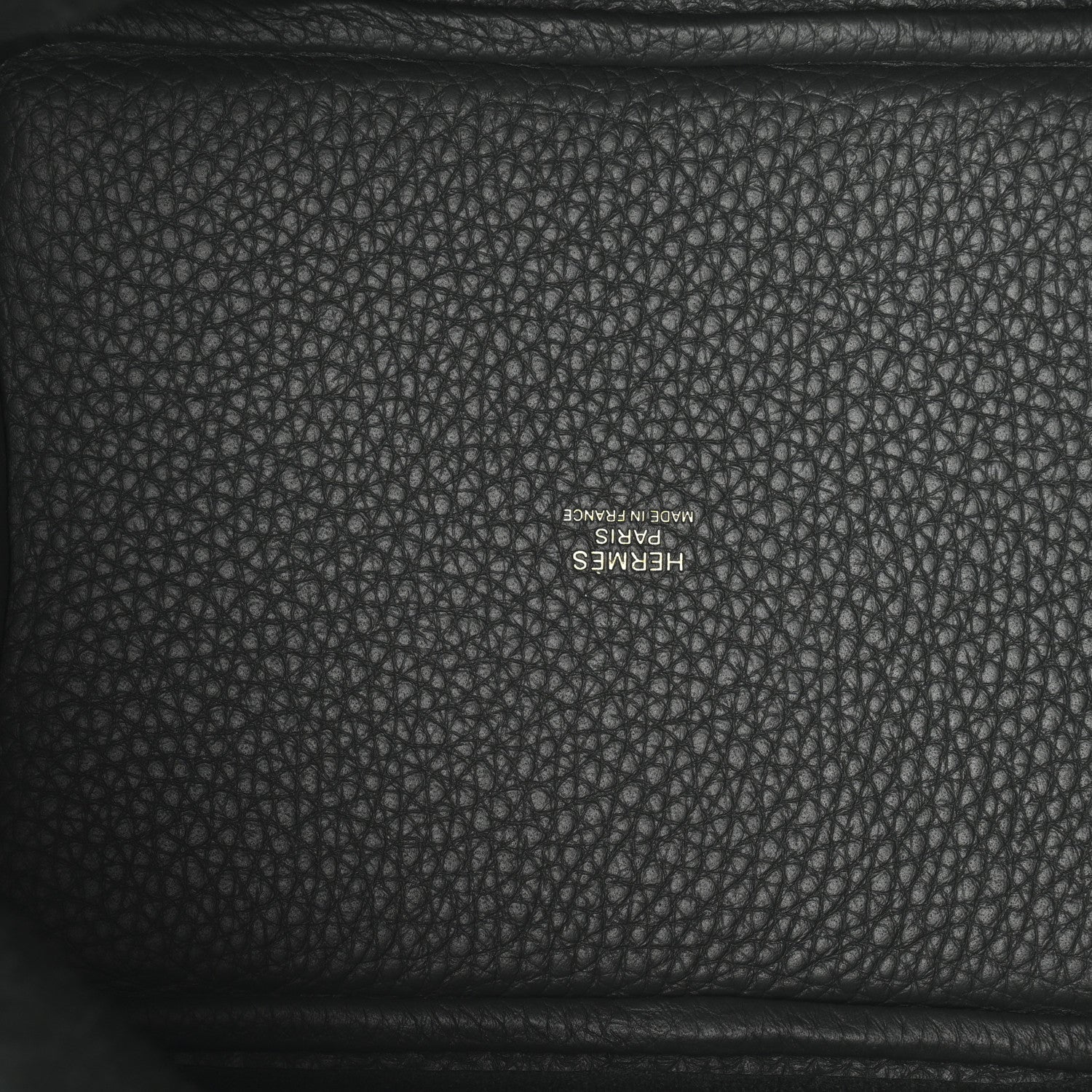 Textured dark green leather interior panel with stamped logo lettering.