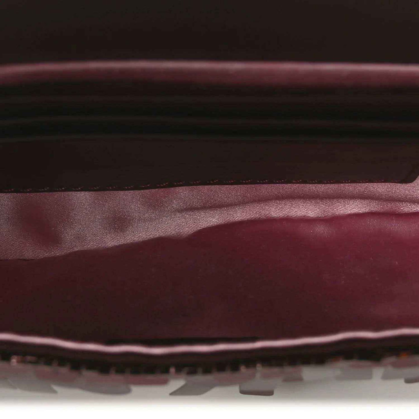 Mini baguette handbag interior view with dark lining and red-toned sequin edge trim