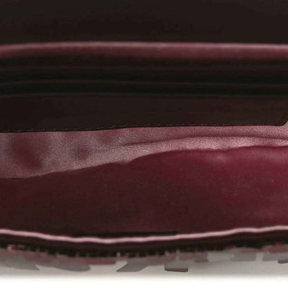 Mini baguette handbag interior view with dark lining and red-toned sequin edge trim
