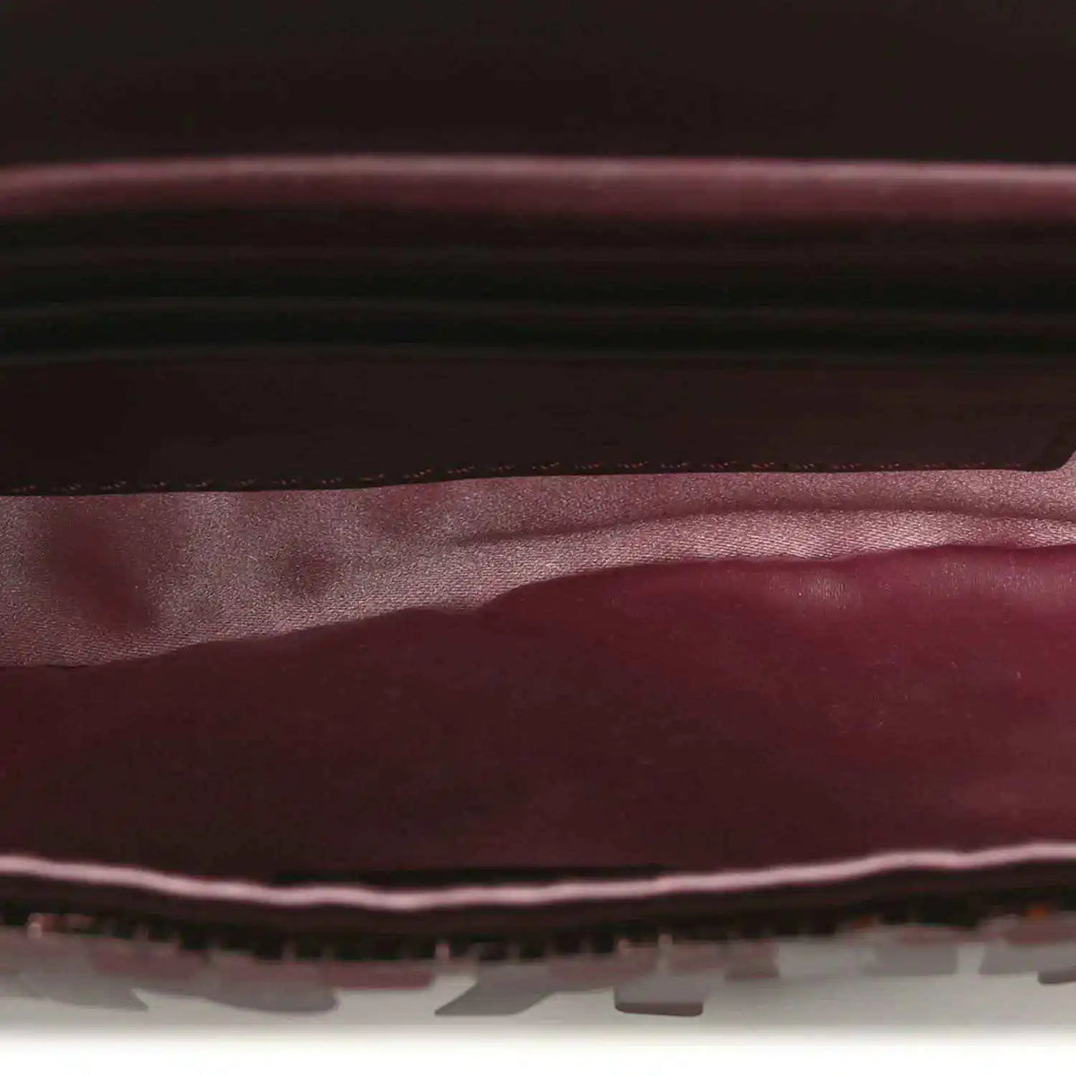 Mini baguette handbag interior view with dark lining and red-toned sequin edge trim