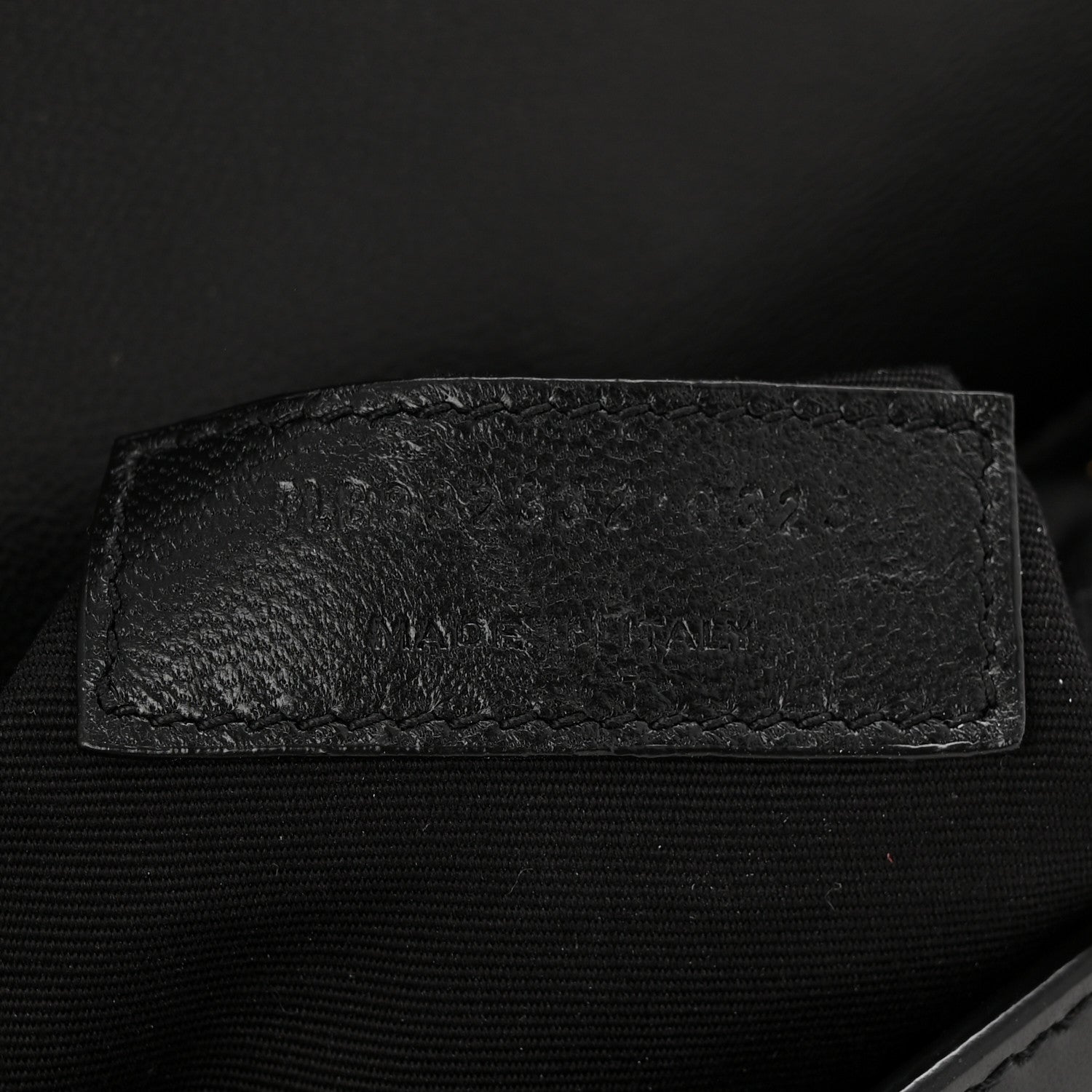 Saint Laurent black leather interior detail with embossed text area