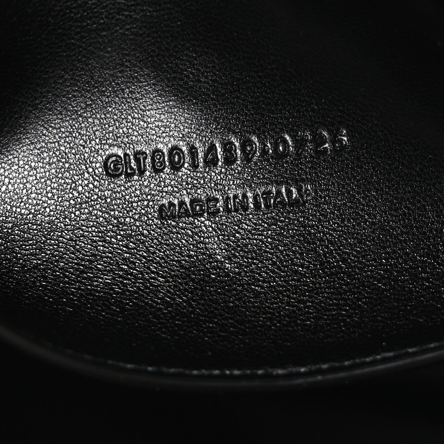 Black leather bag with stamped serial text on interior panel