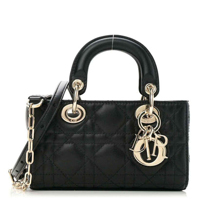 Black lambskin handbag with quilted cannage pattern, top handles, and gold chain charm
