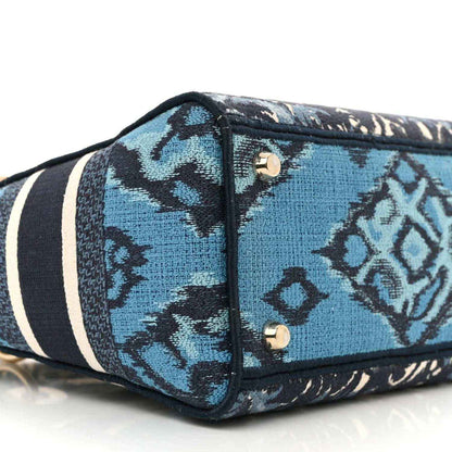 Bottom front panel with blue and navy toile print, black piping, and two metal snaps