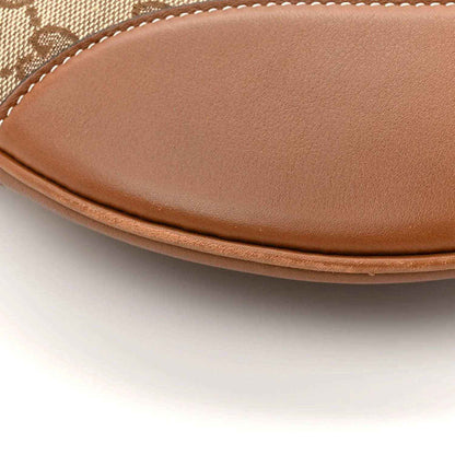 Large shoulder bag bottom edge with brown leather trim and smooth leather flap
