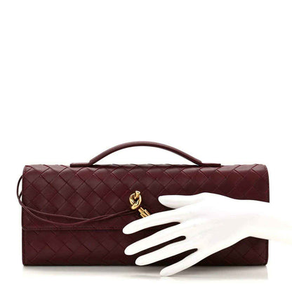 Burgundy Intrecciato clutch bag with top handle, gold clasp, and open flap