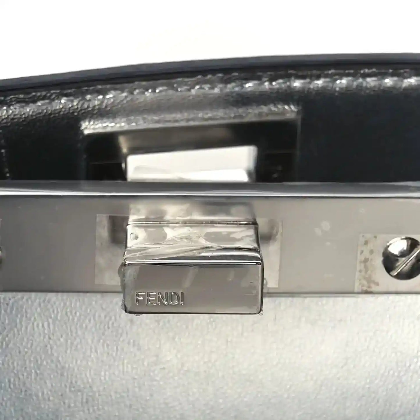 FENDI engraved metal plaque on satchel interior flap with dark leather backing