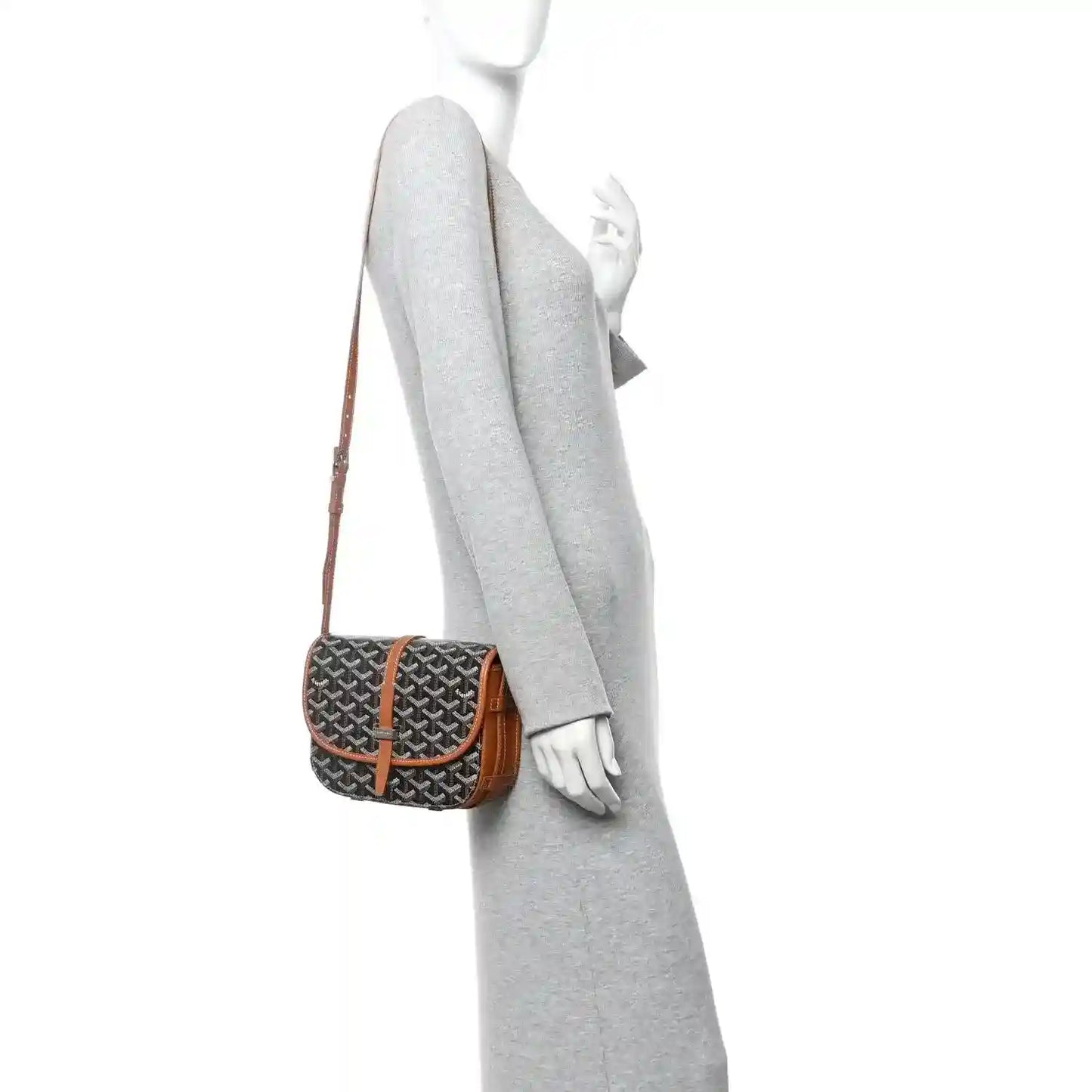 Monogram crossbody bag with dark patterned canvas and tan strap, worn on a model