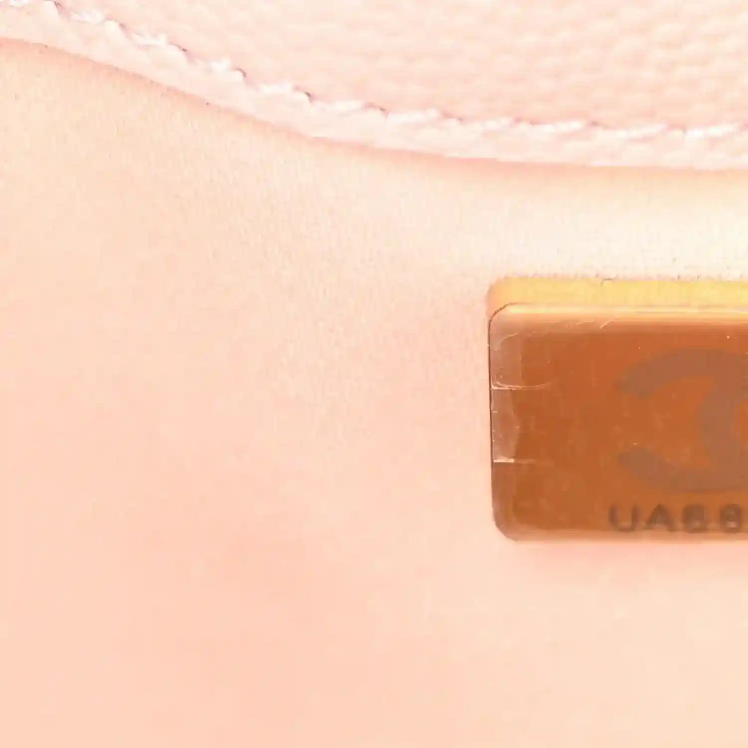 Light pink quilted leather mini handbag corner with gold-toned logo tab detail