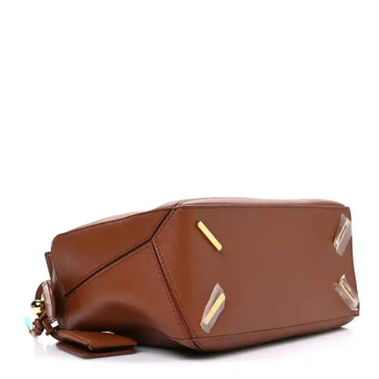 Small Puzzle bag base view in pecan brown leather with gold-tone bar and studs