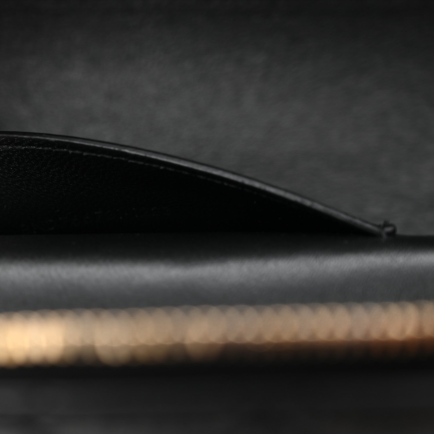 Saint Laurent mini vanity case side view with curved black leather top edge and stitching