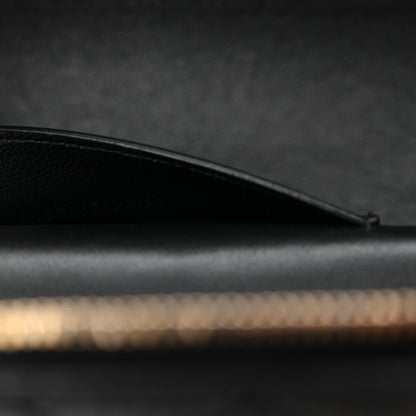Saint Laurent mini vanity case side view with curved black leather top edge and stitching