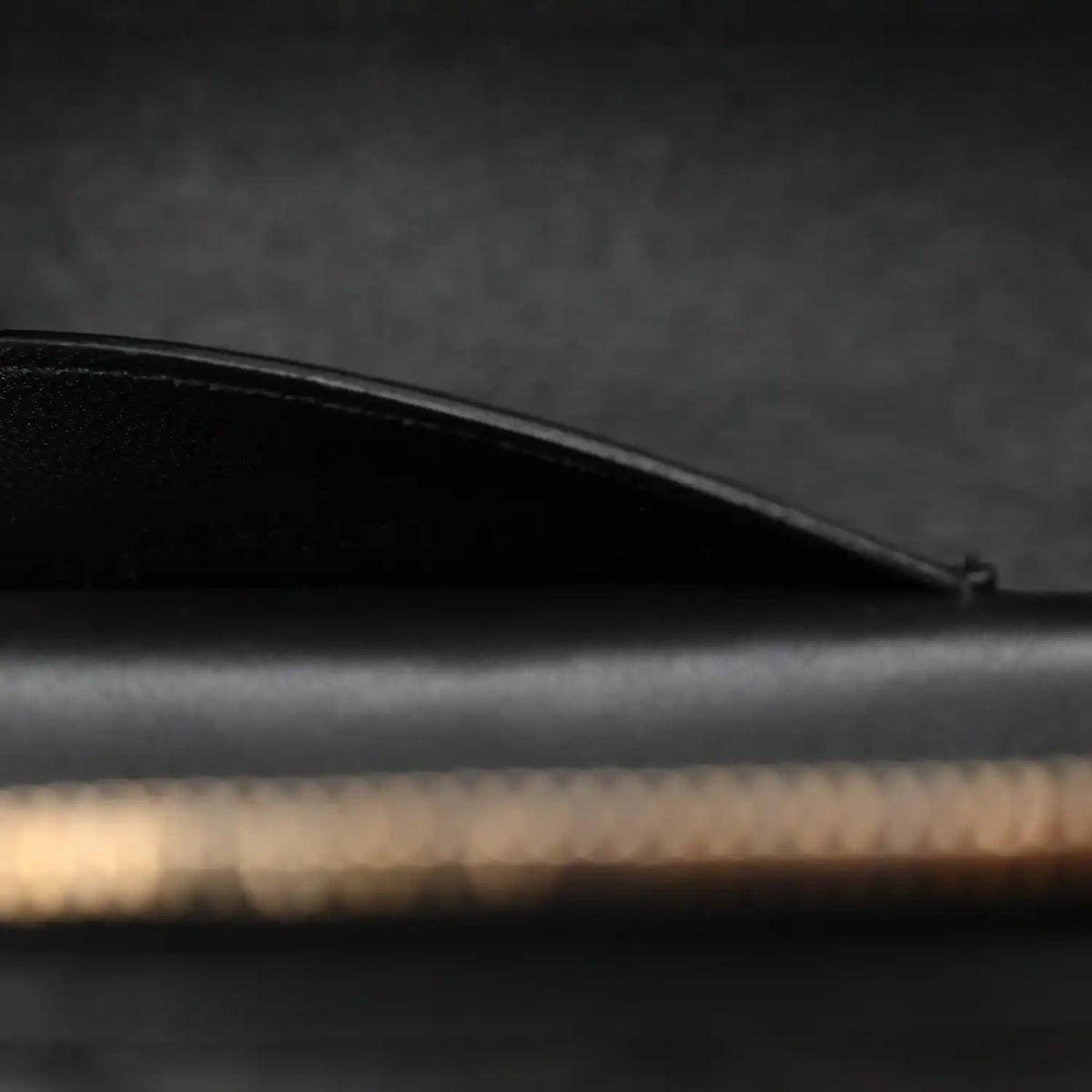 Saint Laurent mini vanity case side view with curved black leather top edge and stitching