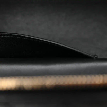 Saint Laurent mini vanity case side view with curved black leather top edge and stitching