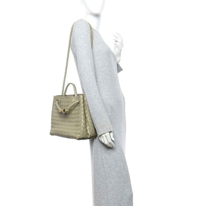 Medium leather tote worn at side view with short handles and crossbody strap