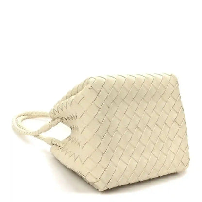 Light cream woven small bag with adjustable drawstring and braided cord, angled