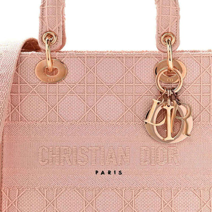 Pink canvas bag front with gold rings, Dior charm, and “CHRISTIAN DIOR PARIS”