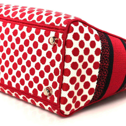 Red and white polka dot canvas bag corner with red strap and gold hardware