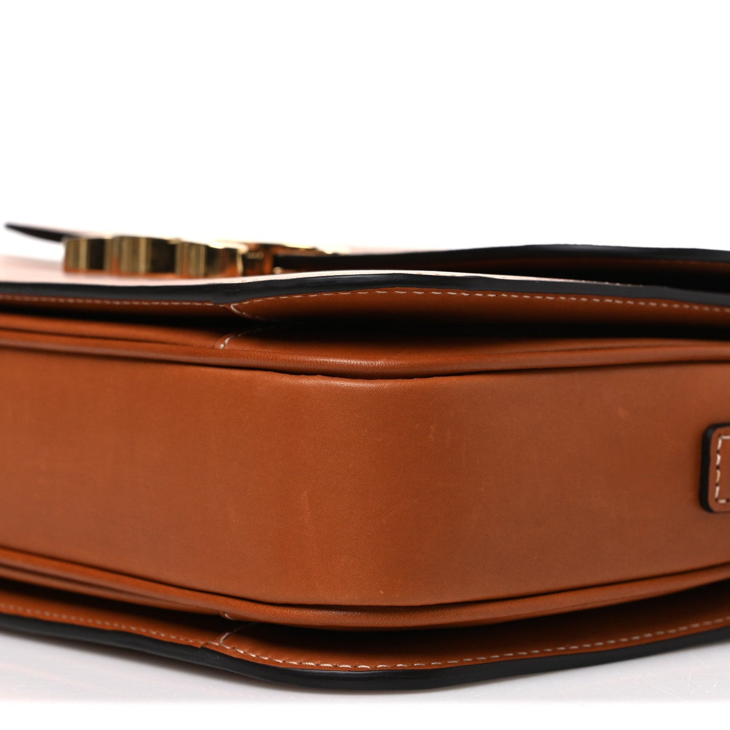 Tan leather bag side profile with stitched trim and gold-tone clasp hardware detail.