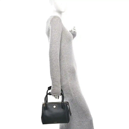 Small black leather handbag with top handles and shoulder strap