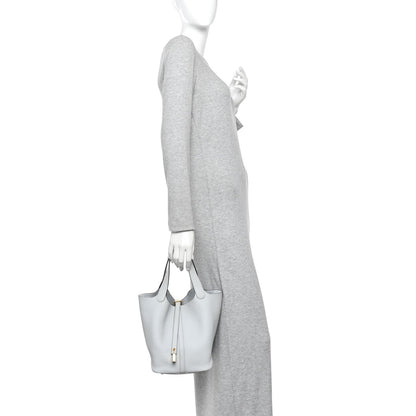 Light blue pebbled leather bucket tote with short handles and lock front