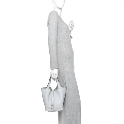 Light blue pebbled leather bucket tote with short handles and lock front