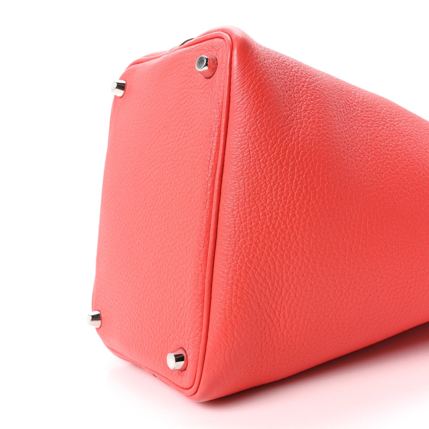 Red leather tote bag side with metal feet and top edge seam detail