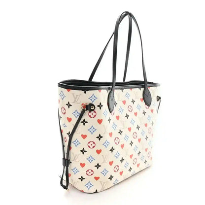 White monogram tote bag with black top handles, side profile, and zipper pull
