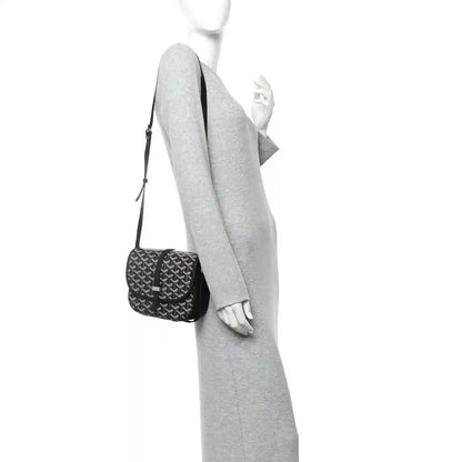 Black jacquard mini messenger bag worn crossbody on a person, adjustable strap