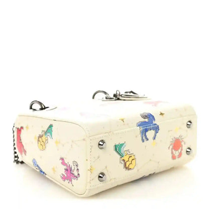 Mini Lady Dior bag side view in white pixel zodiac leather with silver studs