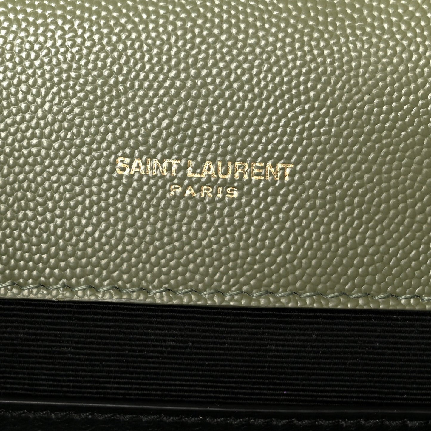 Saint Laurent Paris embossed on light sage leather panel