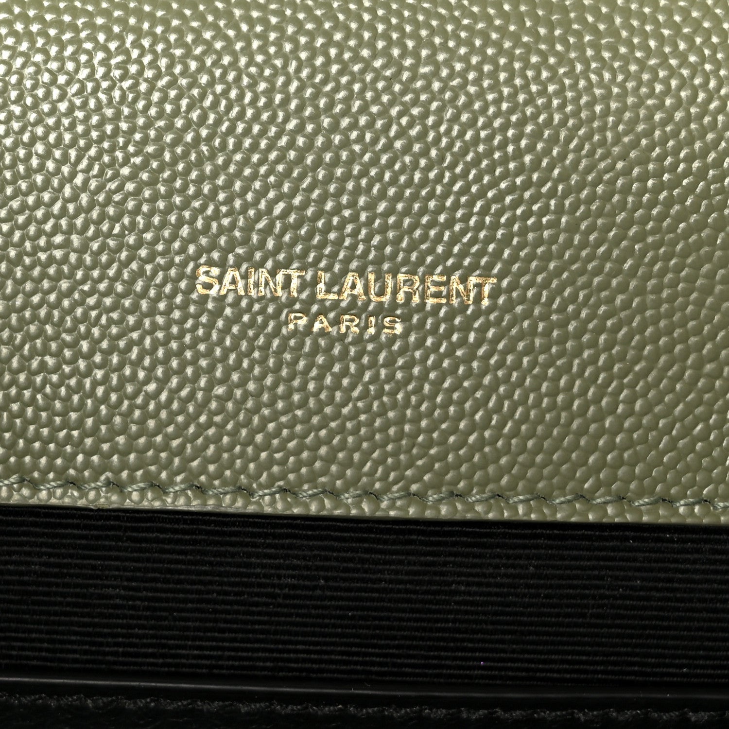 Saint Laurent Paris embossed on light sage leather panel