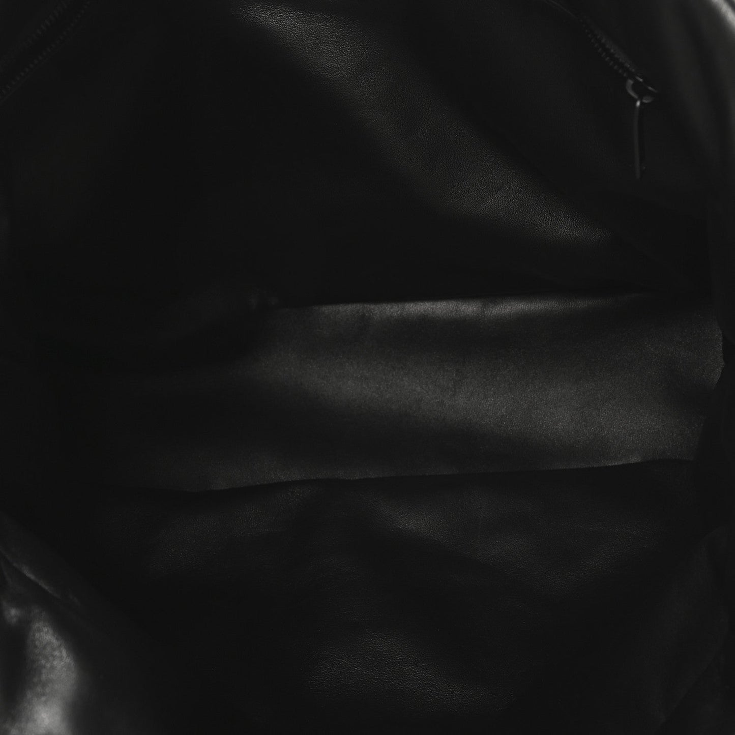 Black lambskin puffer tote close-up of smooth quilted leather surface.