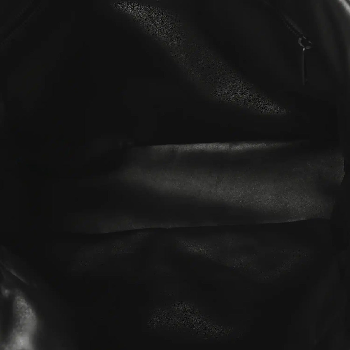 Black lambskin puffer tote close-up of smooth quilted leather surface.