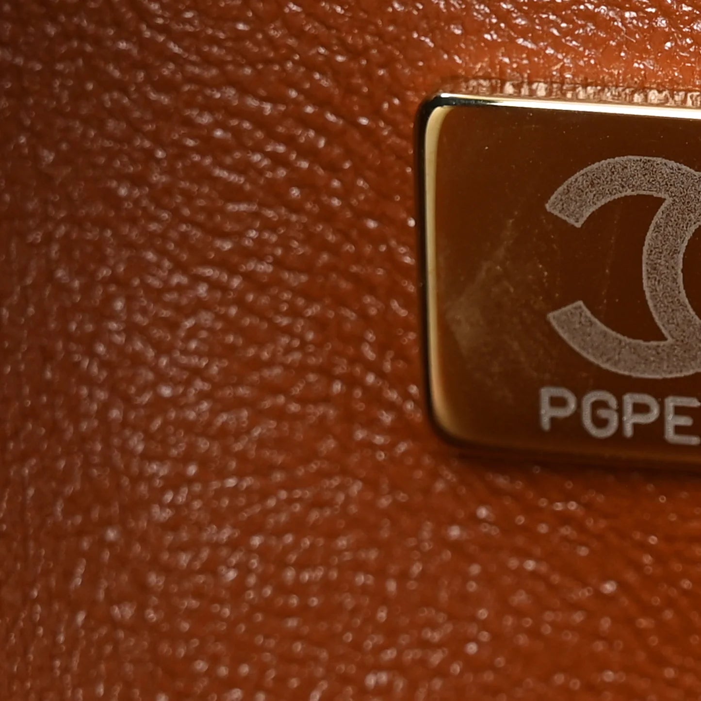 Chanel Jumbo Double Flap bag detail with metal engraving and leather texture close-up