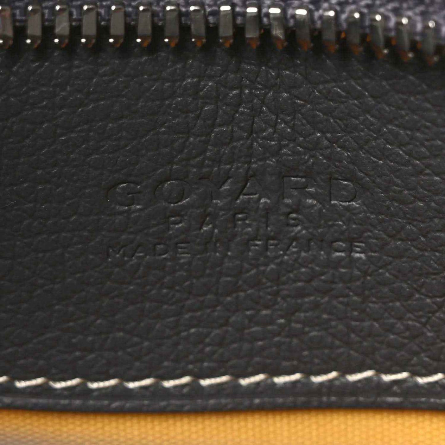 Embossed Goyard logo on dark leather panel