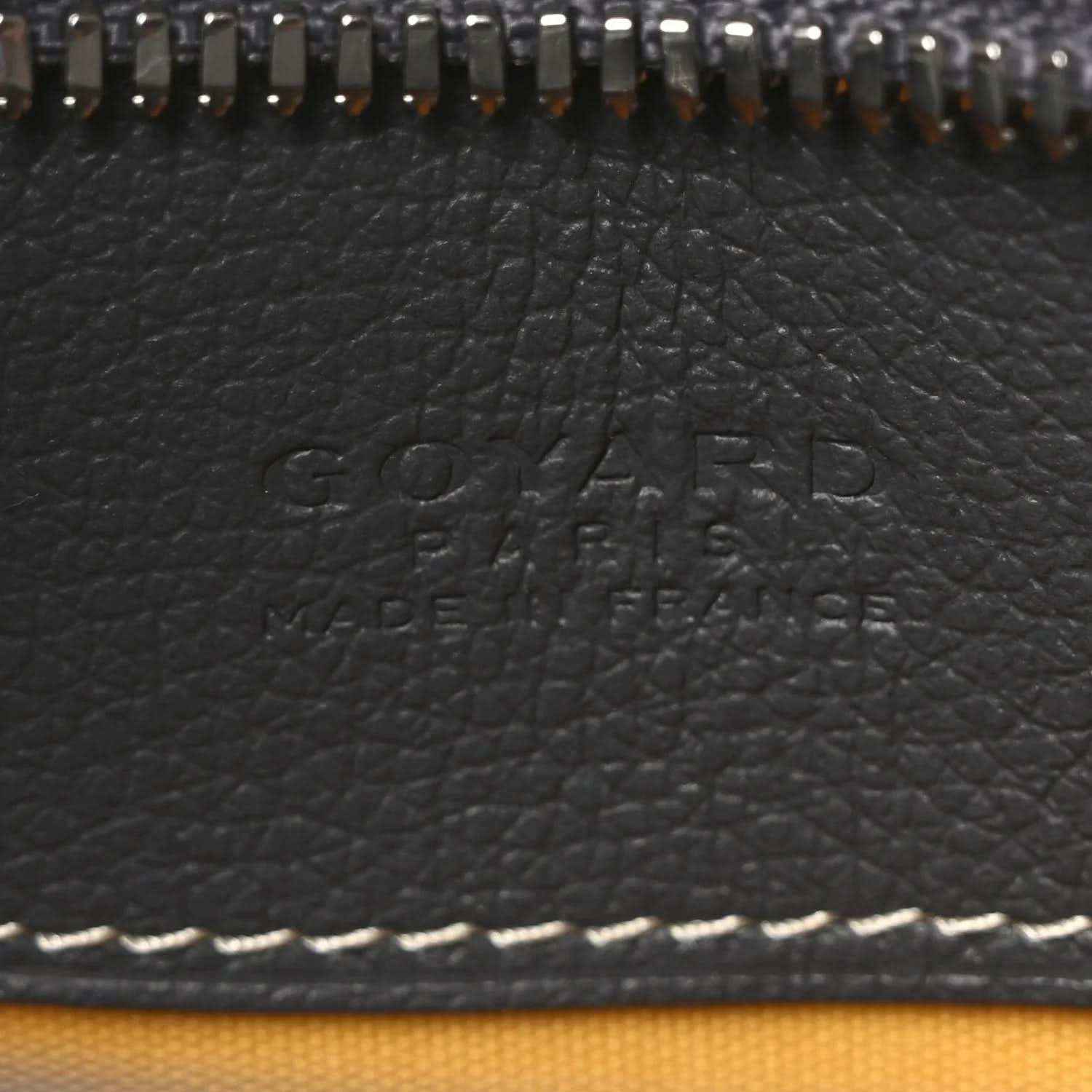 Embossed Goyard logo on dark leather panel